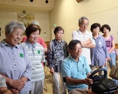 7月講座で模擬運転の機器で危険さを学ぶ受講生らの写真