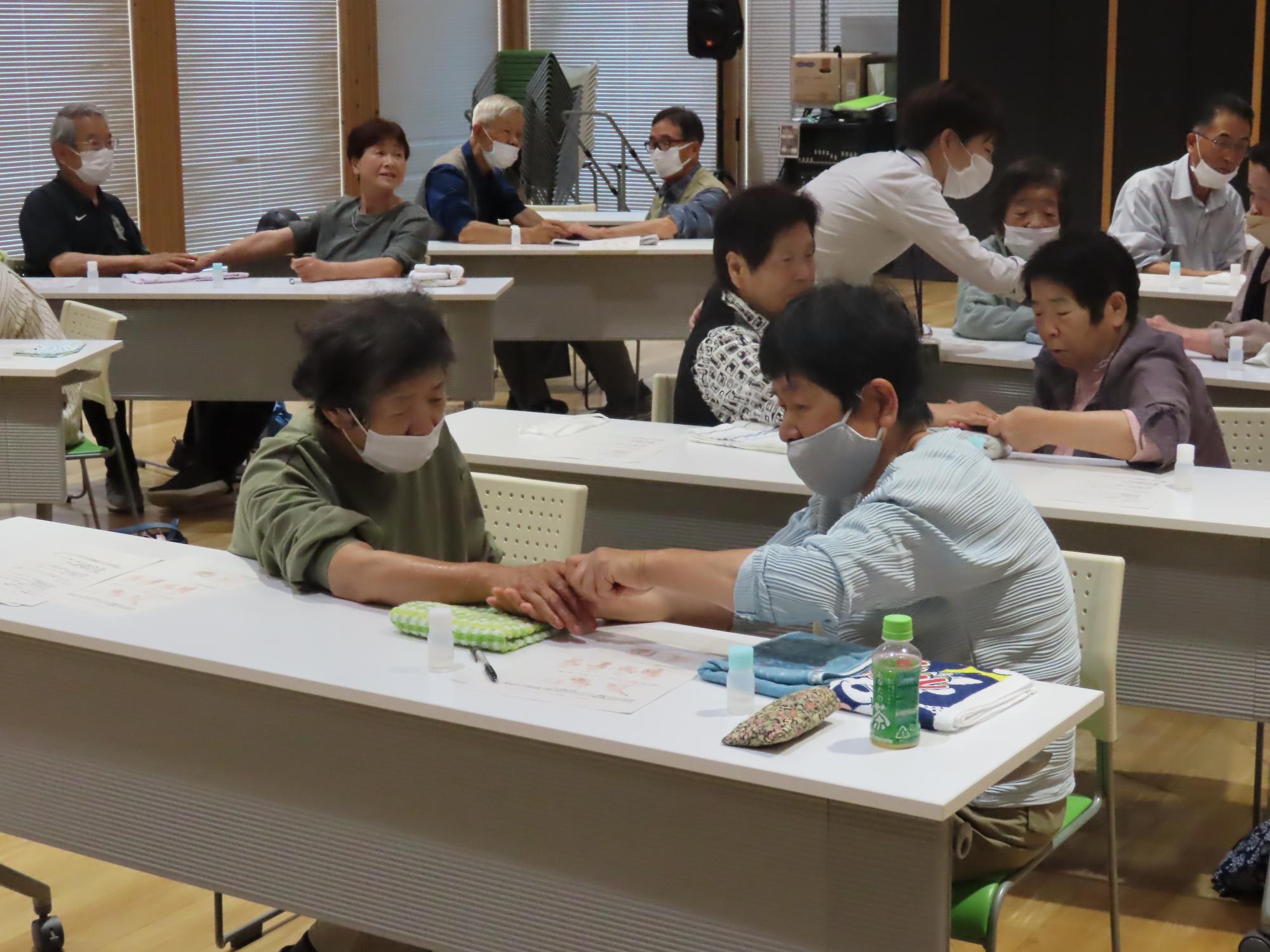 2人1組になってハンドマッサージをするいわみ学園生