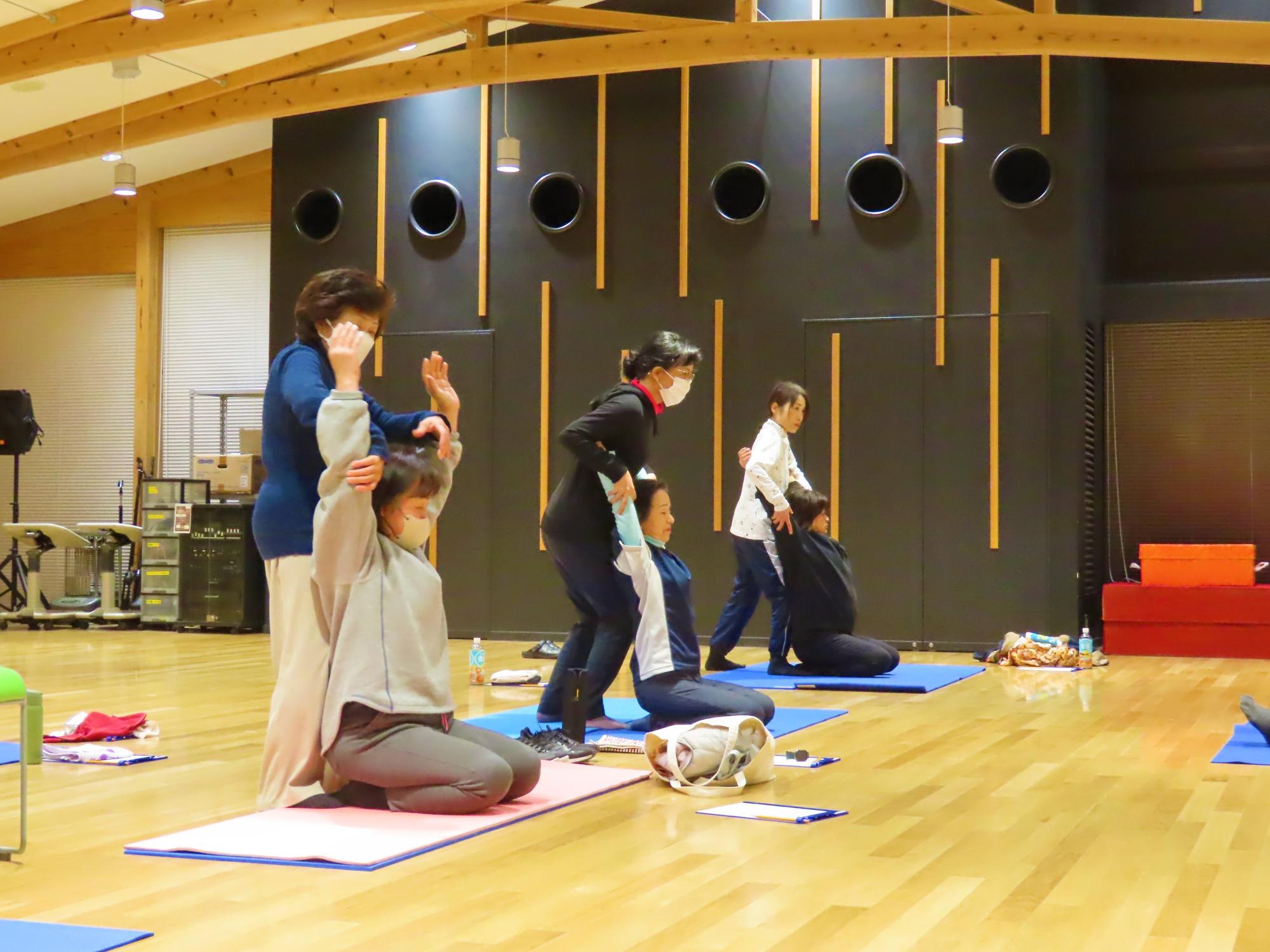 2人1組になって健康体操を行う様子