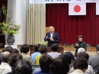 開講式で公演する黒いスーツ姿の男性の写真