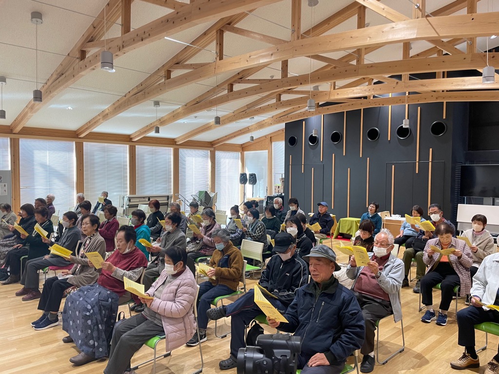 全体合唱で歌詞カードを見ながら歌ういわみ学園生