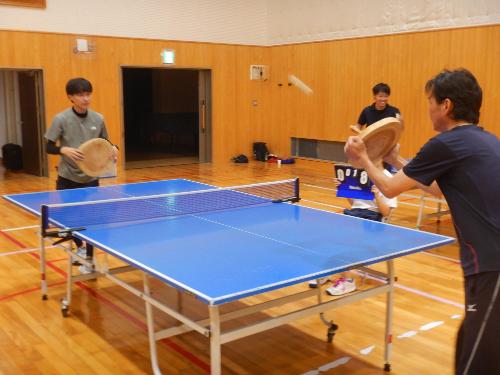 おじいちゃんと子どもが丸太卓球で対戦している写真
