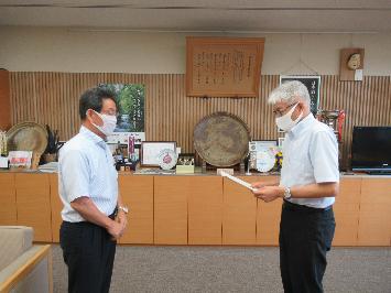 第2次宍粟市総合計画1年延長答申を福元市長に林委員長が手渡そうとしている写真