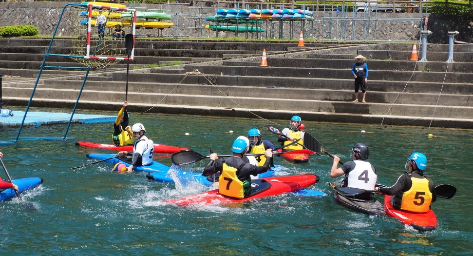 音水湖のカヌーポロ競技場で開かれた選手養成教室に参加した参加者らがカヌーポロ競技に興じている写真