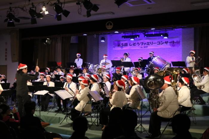 サンタ帽をかぶって合同演奏をしている波賀中学校吹奏楽部の写真