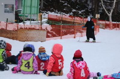 カオナシ姿のスキーヤーとそれを見て驚く児童達の写真