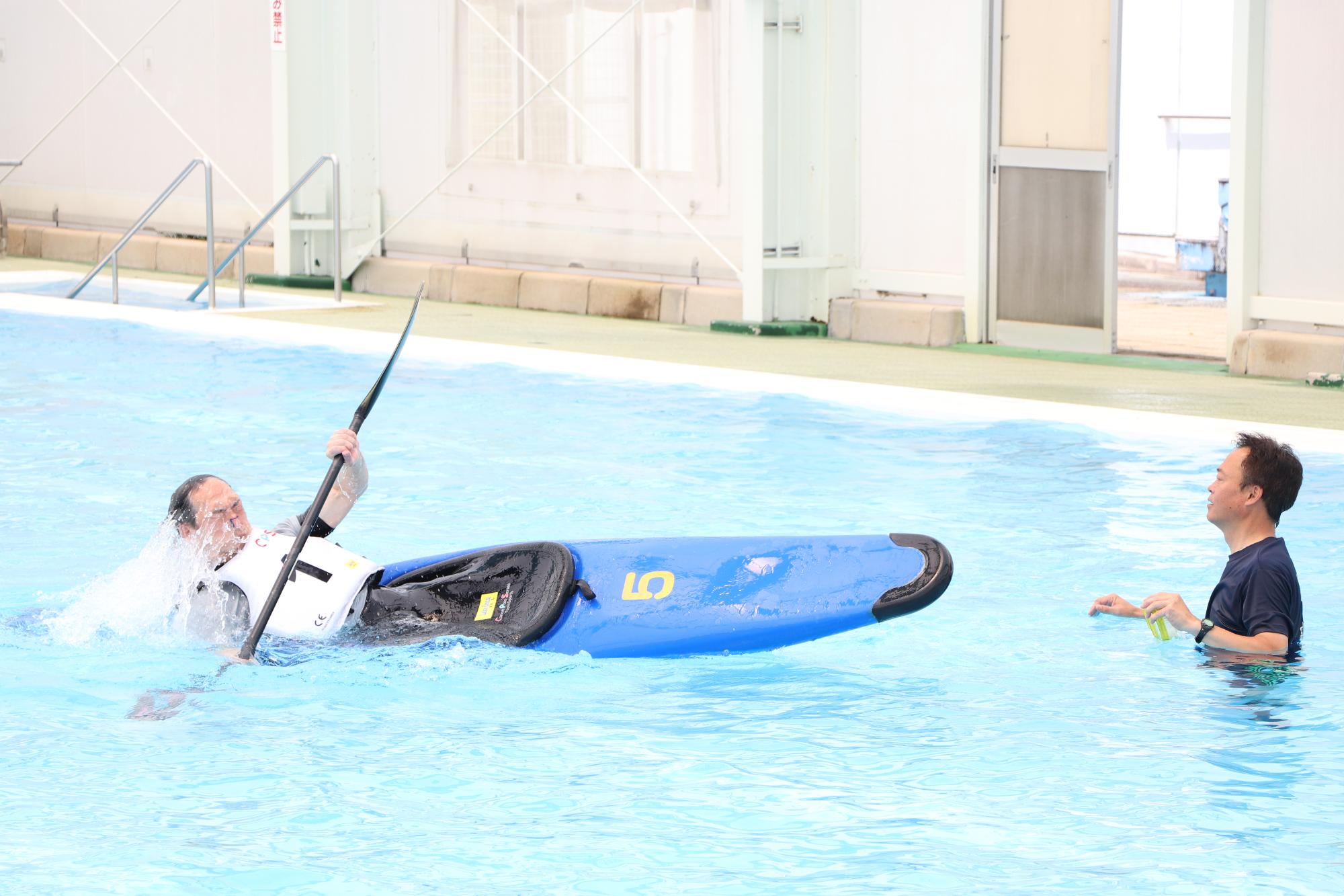 ロール練習で転覆したカヌーから起き上がっている参加者の写真