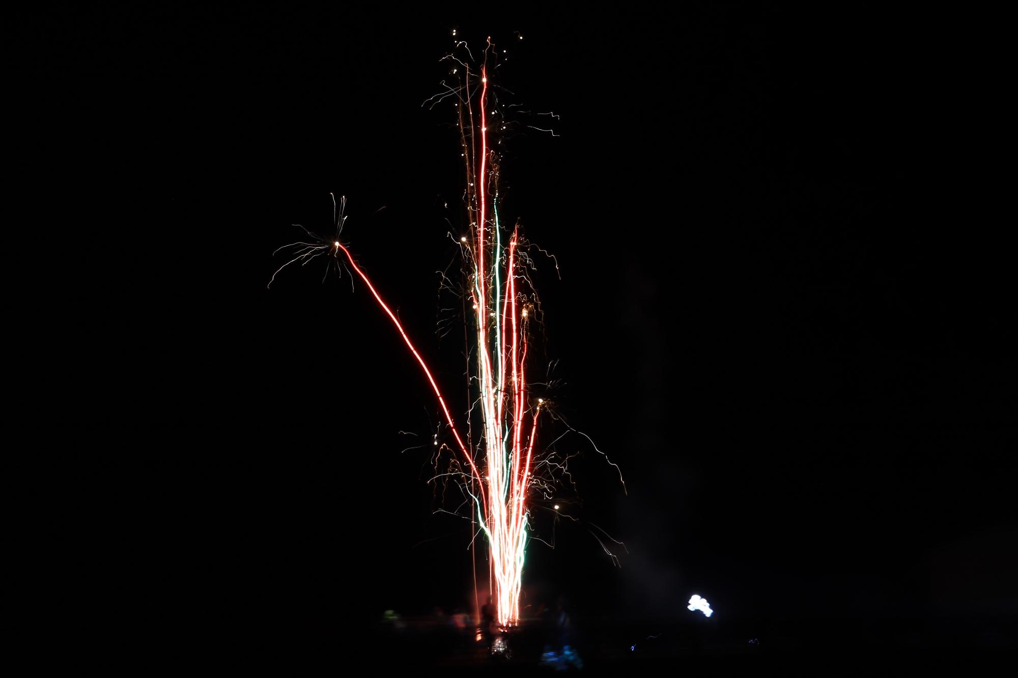 有志らが打ち上げた花火が空に真っ直ぐ上がっている写真