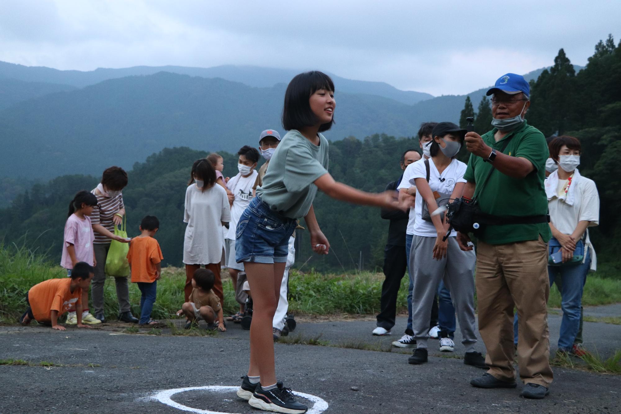 石を泉へ投入する様子