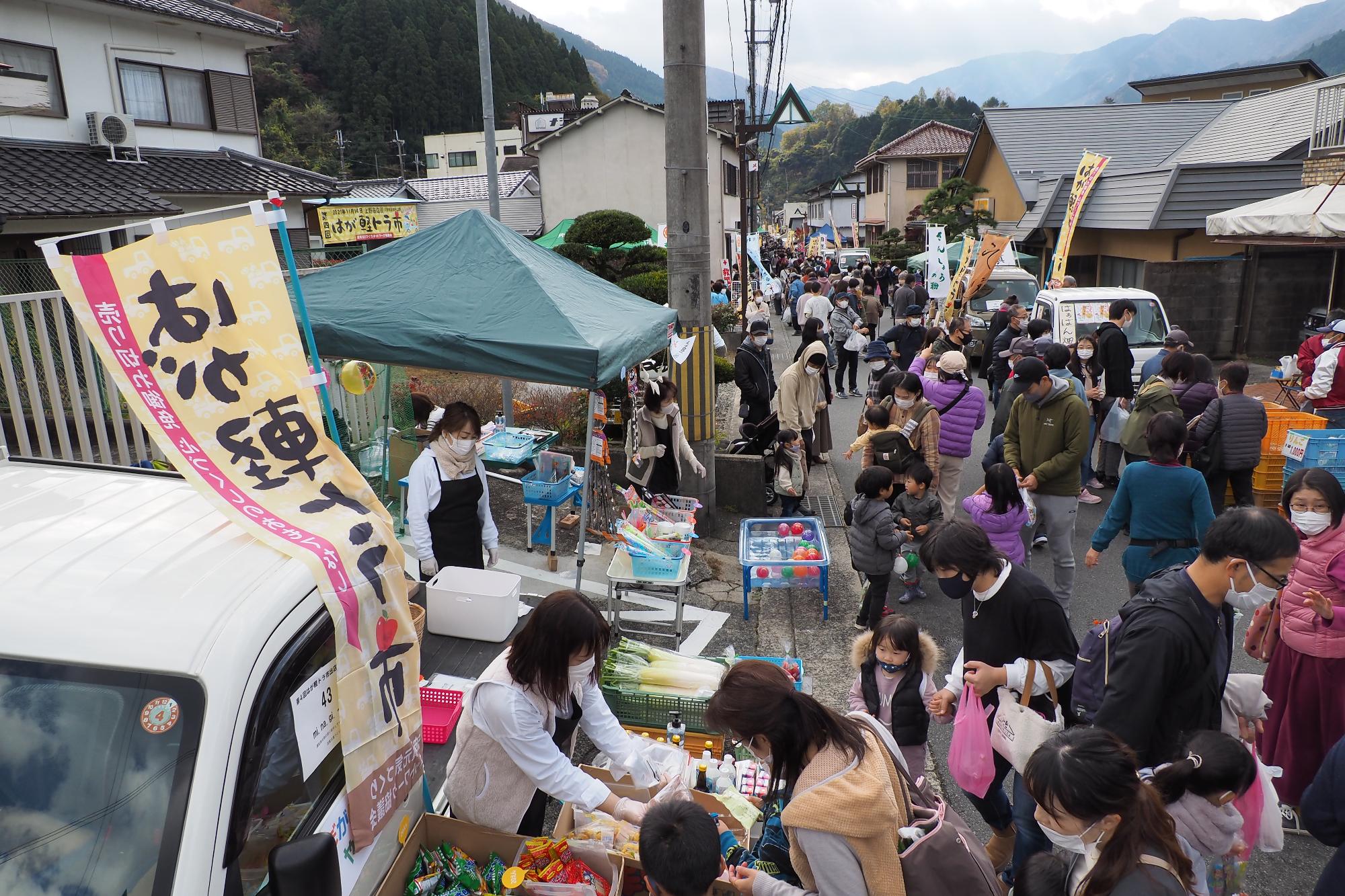 宍粟市波賀町上野の商店街で開催された軽トラ市の会場を多くの来場者らが行き交っている写真