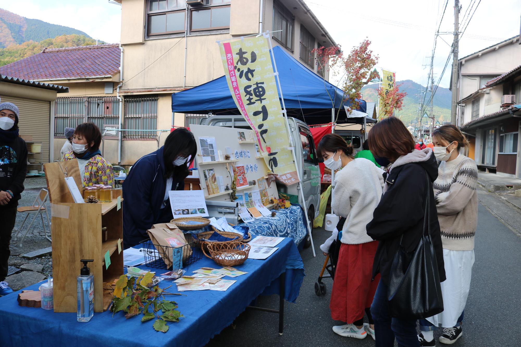 はが軽トラ市のお店の前でお客さんが商品を選んでいる写真