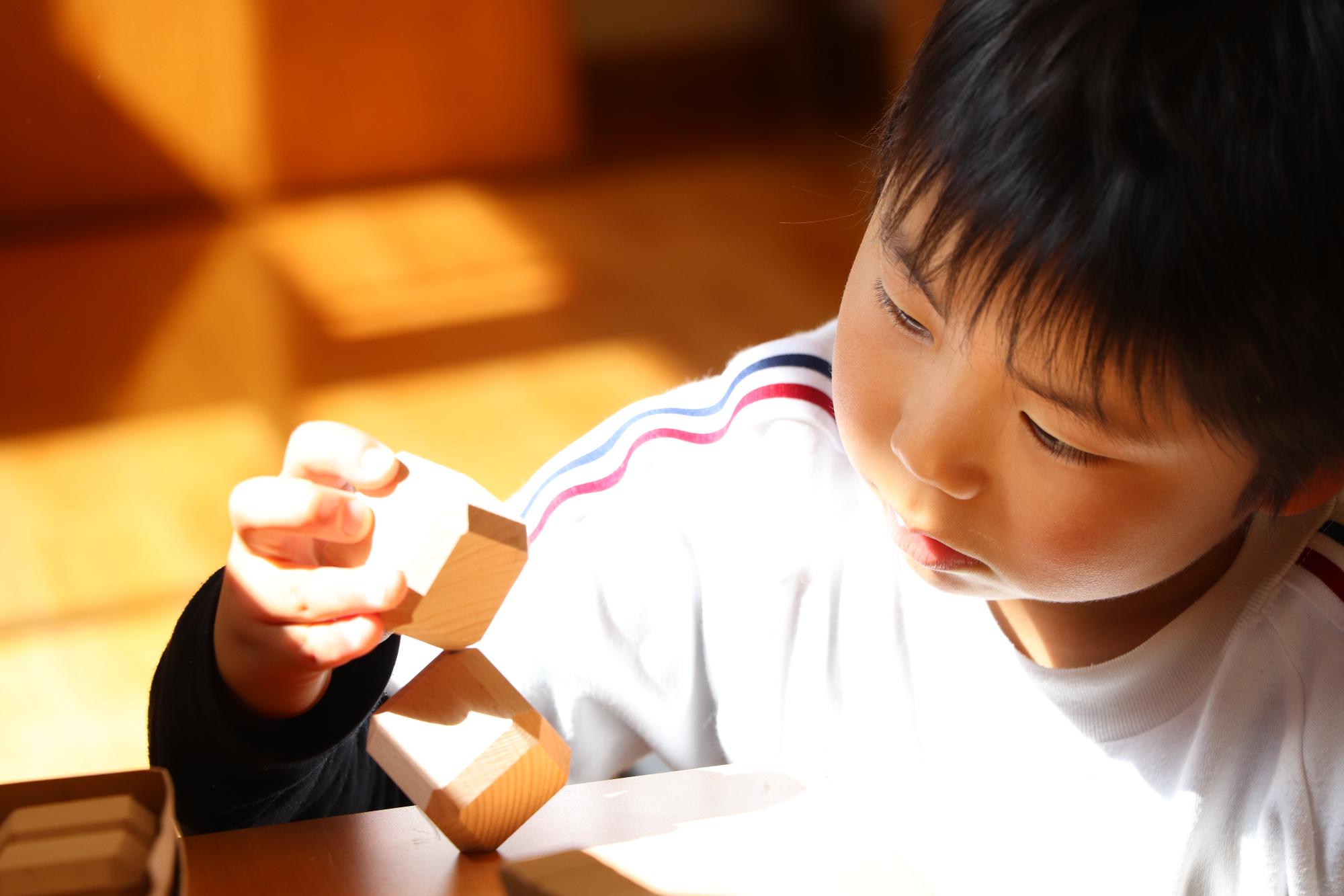 積み木に集中する子どもの写真