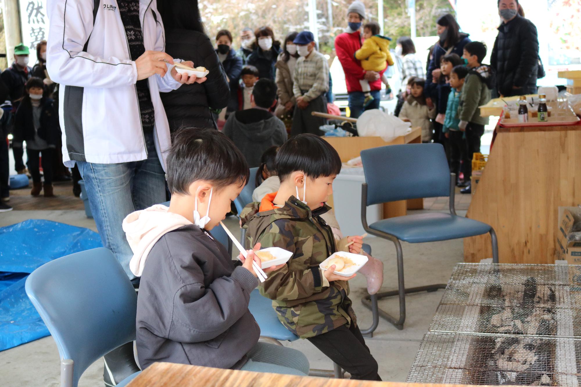 子ども達がつきたての餅を食べている様子