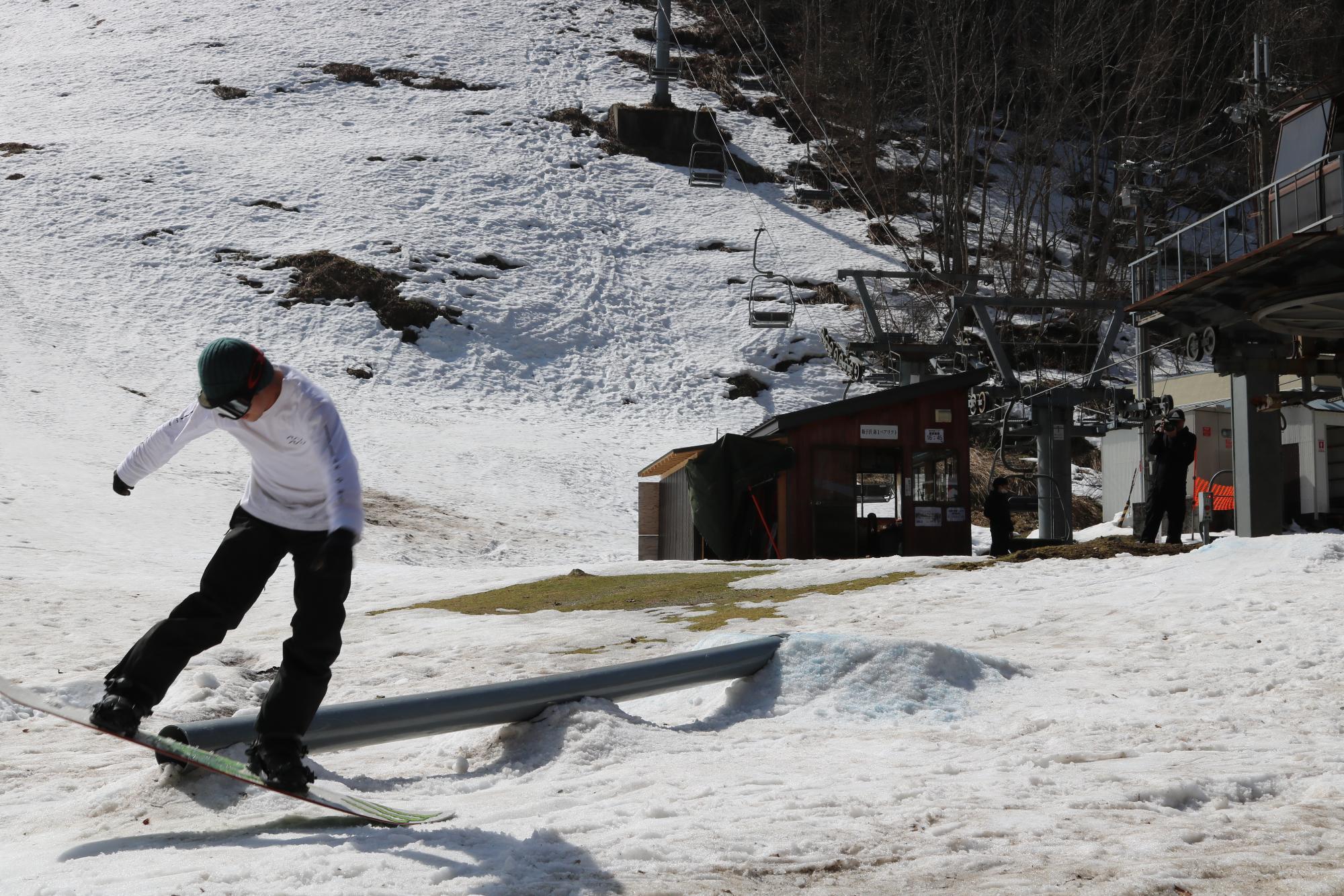 参加者が集めた雪の上に障害物を設置し、スノーボードを楽しんでいる写真