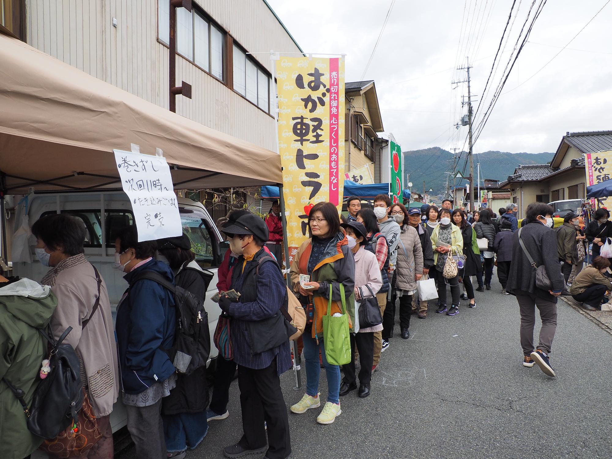 商品を買い求める来場者が行列をつくっている写真