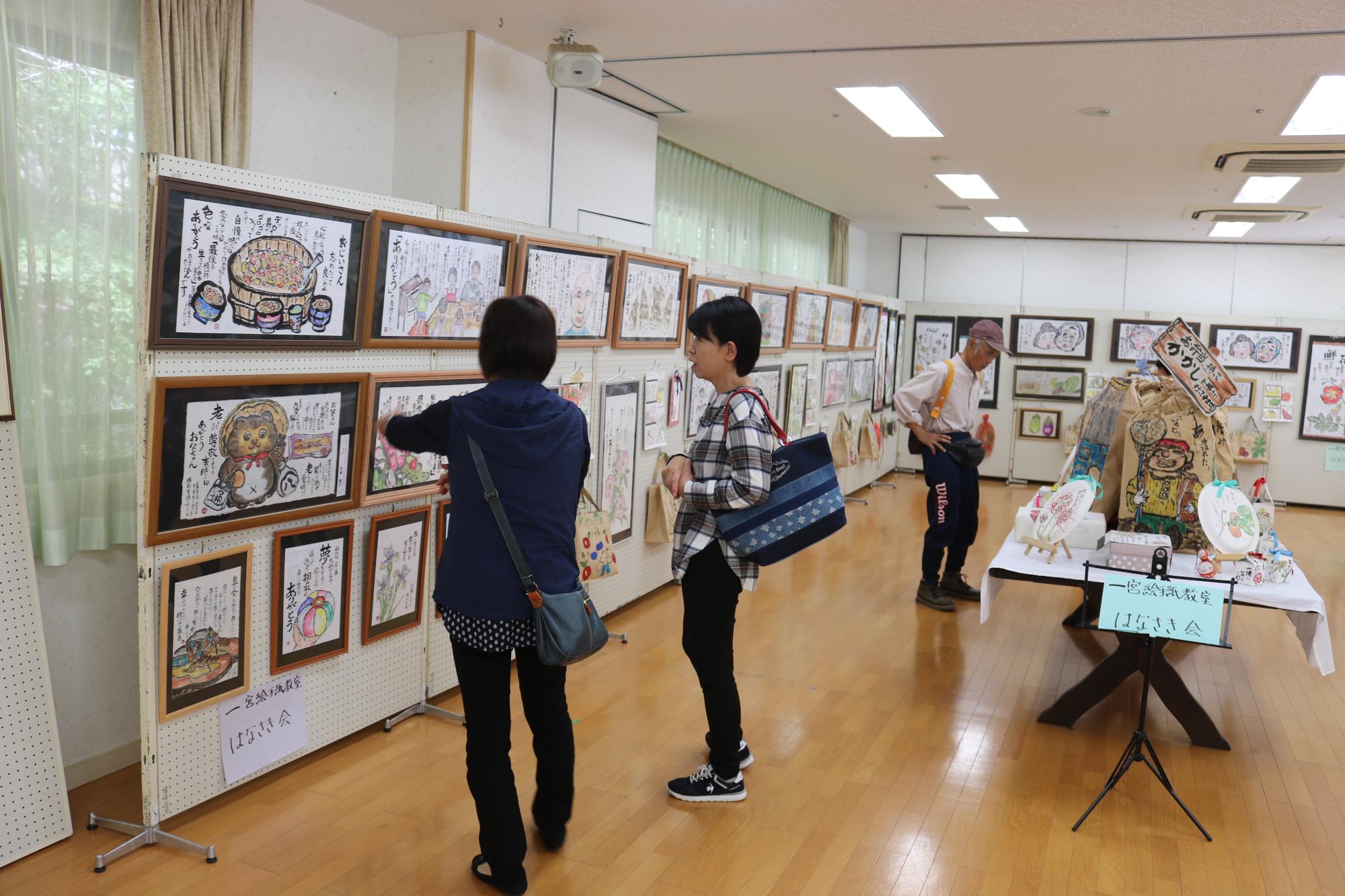 絵手紙や水彩画を熱心に来場者が見ている写真