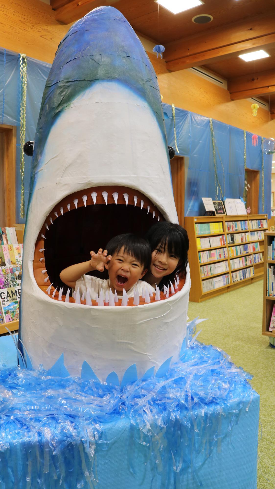 人食いザメ「ジョーズ」の口の中から2人の子どもが顔をのぞかせている写真