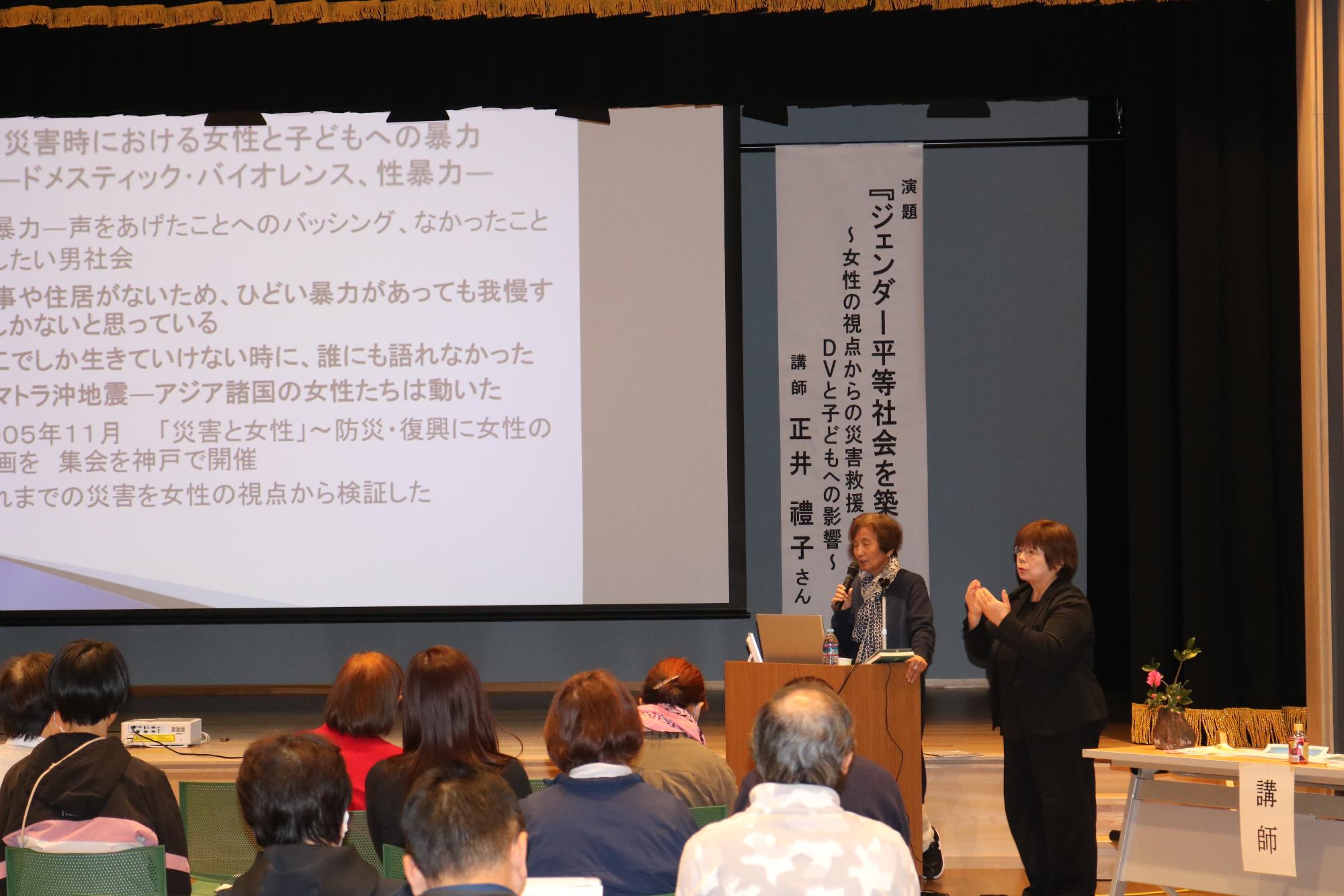 講師の正井禮子さんが演台に立ち、来場者に向けて話をしている写真