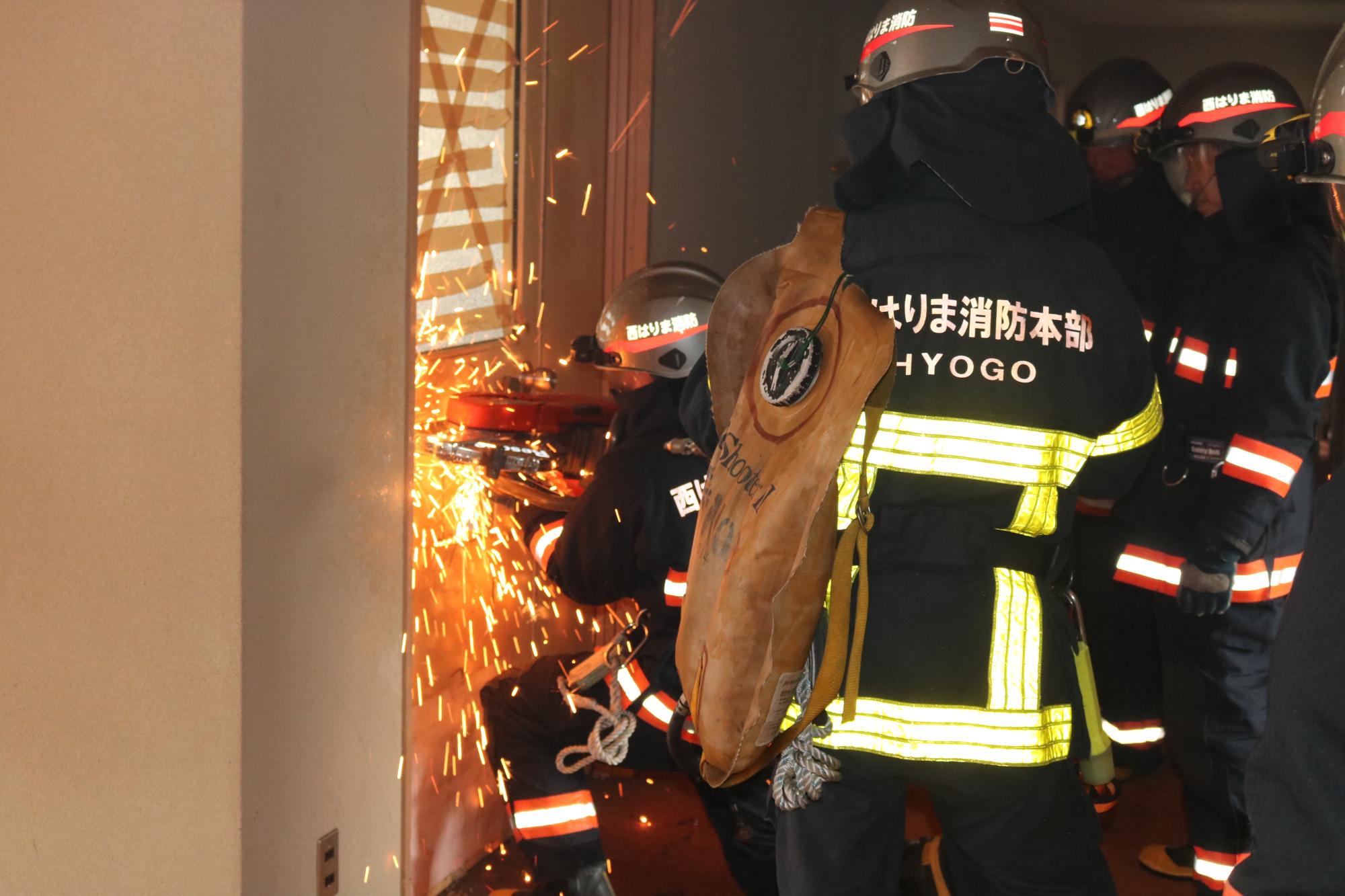 宍粟消防署の署員が救助訓練で旧センター波賀内の鉄製の扉をエンジンカッターで破壊している写真