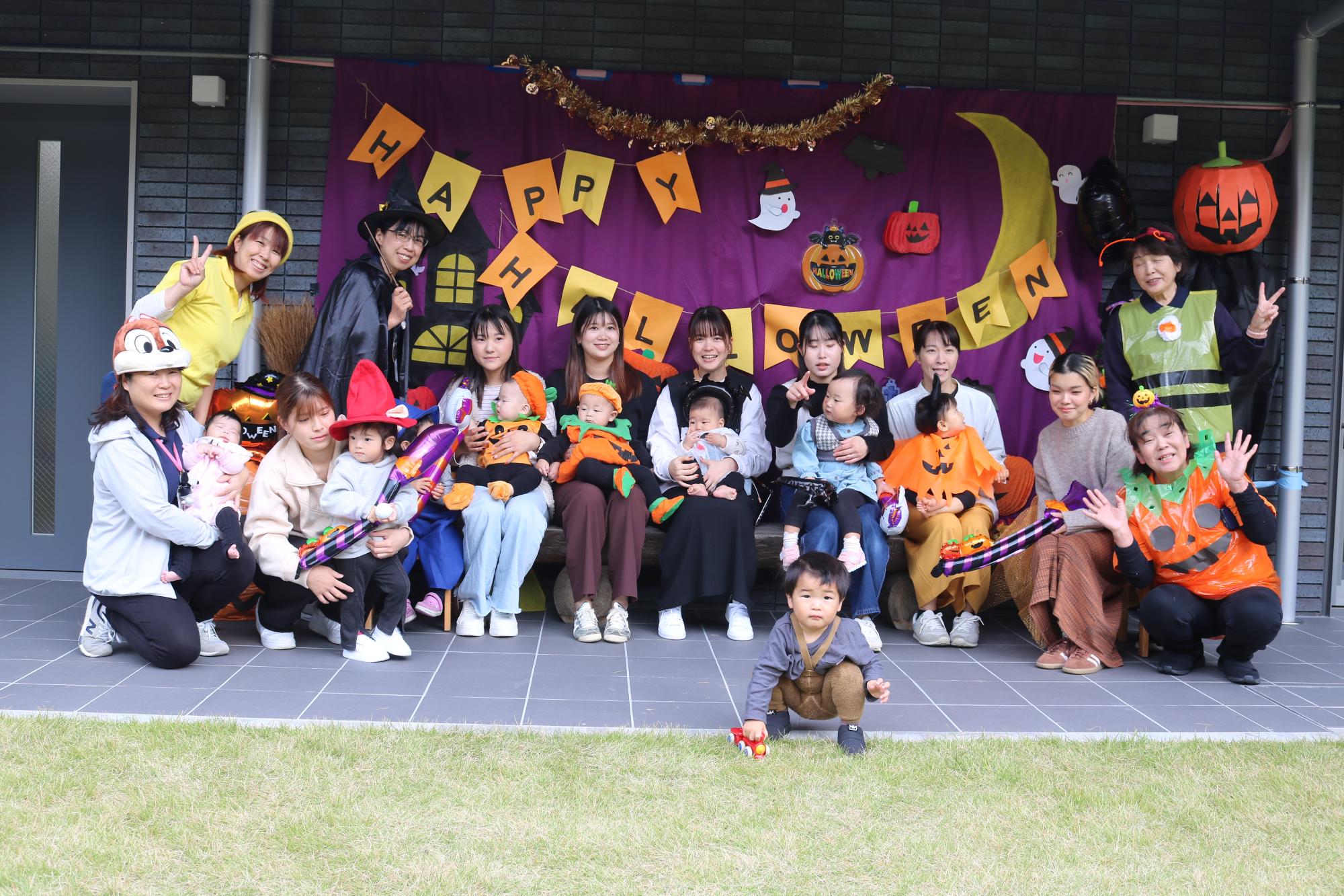 ハロウィンの仮装した子どもたちと一緒に、保護者や子育て支援センターの職員も入って記念撮影した写真