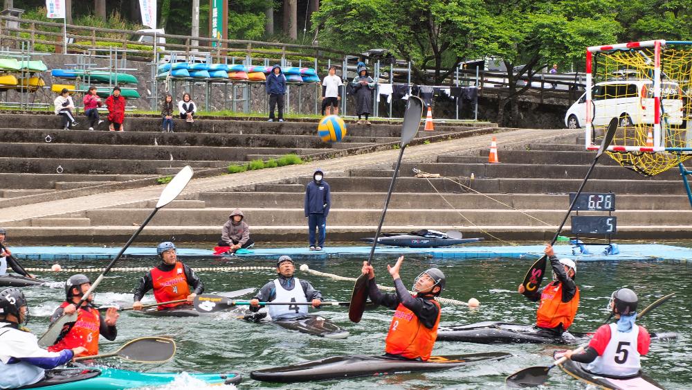 音水湖でカヌーポロ大会の参加者らがカヌーポロの試合をしている写真