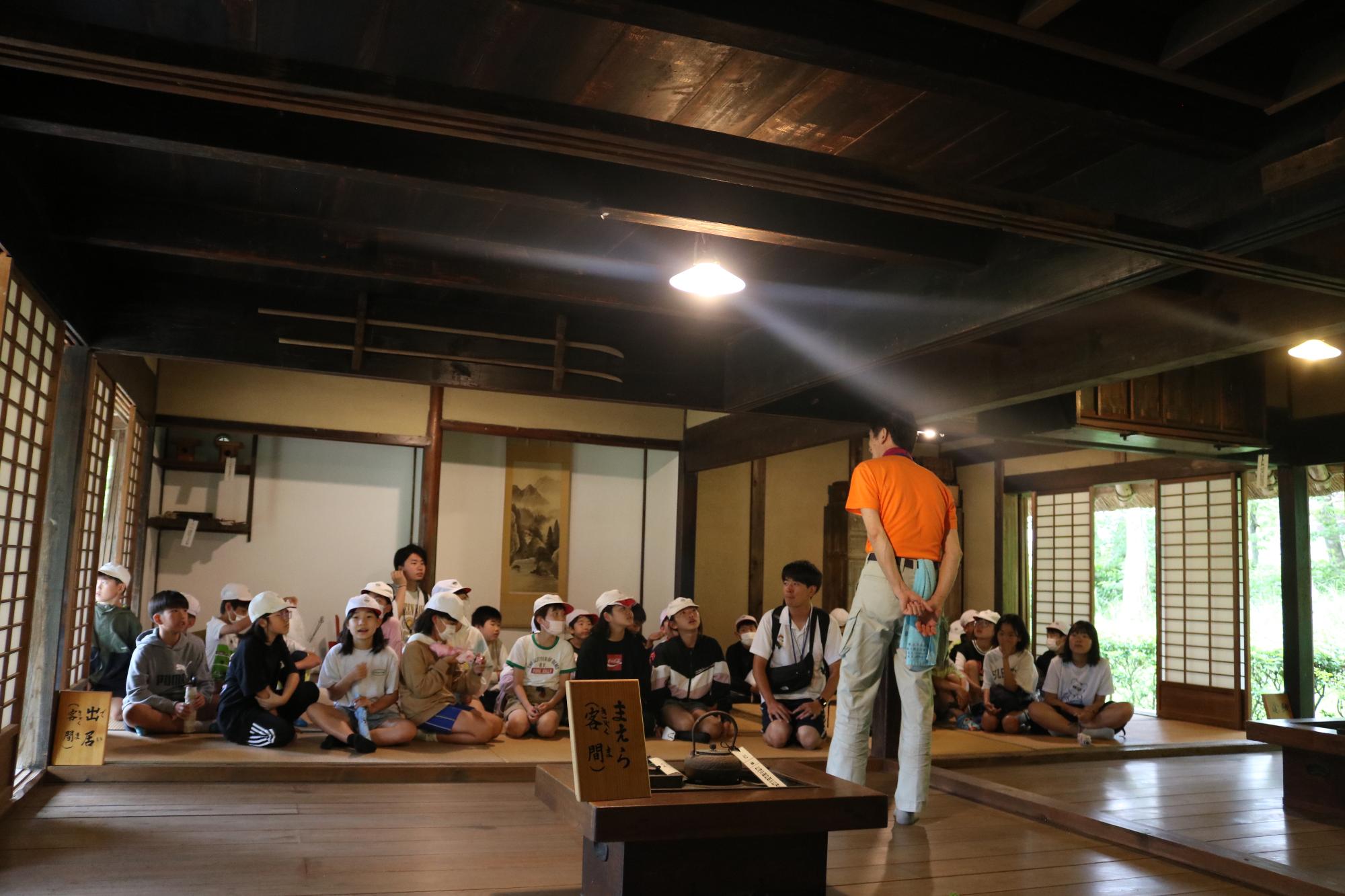 波賀歴史伝承の家で宍粟市の職員から昔の暮らしについて話を聞いている子どもたちの写真