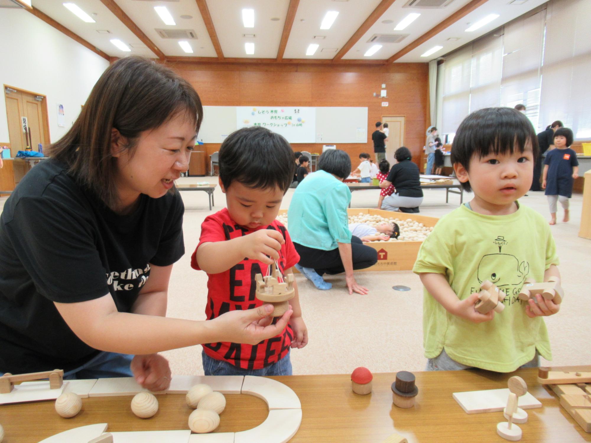 2人の子どもが木のおもちゃで遊んでいる写真