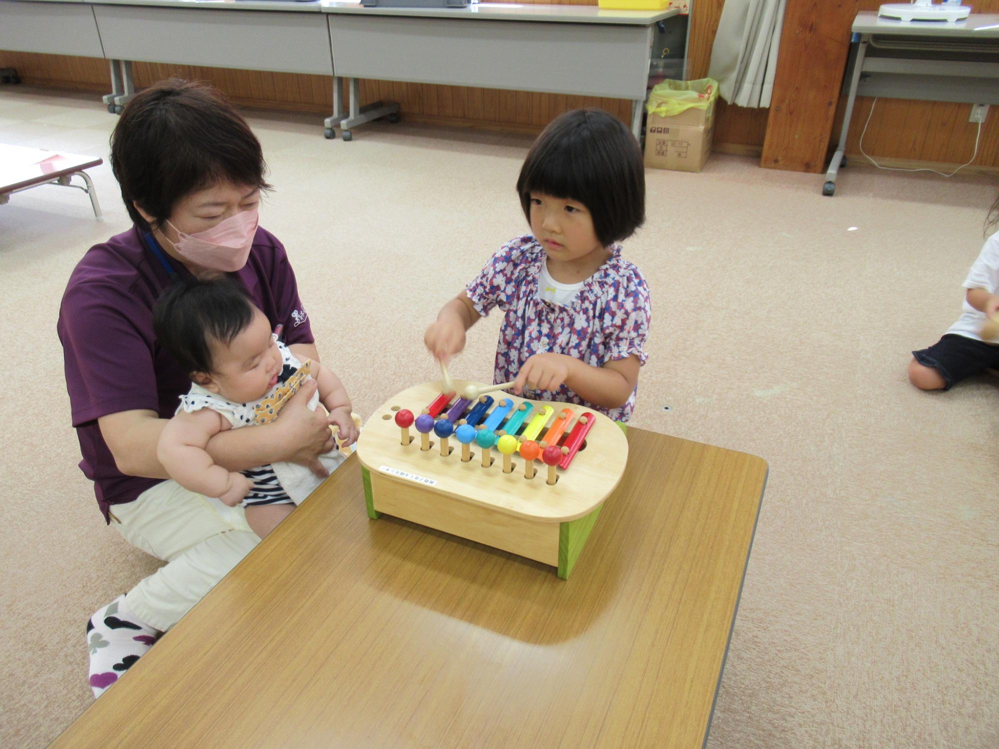 木琴のおもちゃで子どもが遊んでいる写真