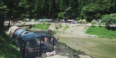 川沿いのキャンプ場でテントを設置している写真