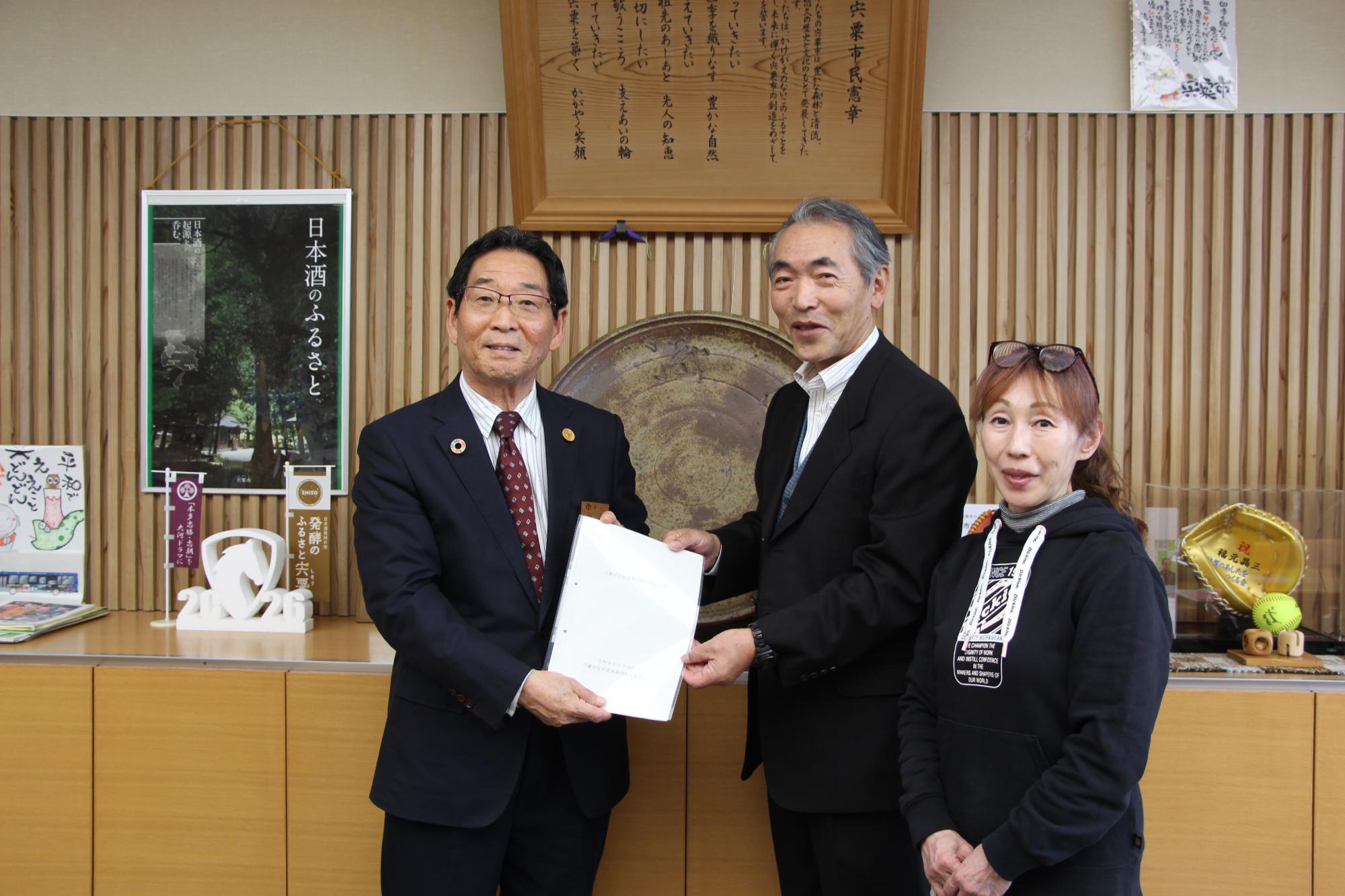 自治基本条例検証委員会委員長から市長へ報告書を提出している写真