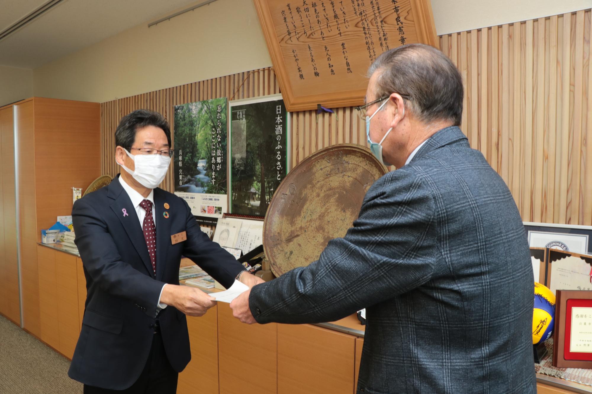 宍粟市公共料金審議会の森脇会長から答申書を受け取る福元市長の写真