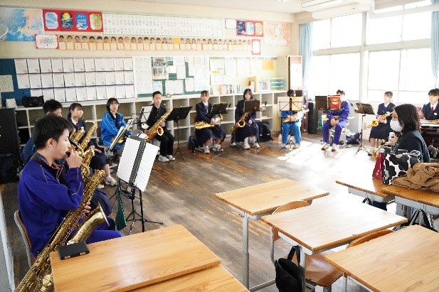 合同講習会に参加した中学校の吹奏楽部員が、教室で円になって楽器演奏を行っている写真