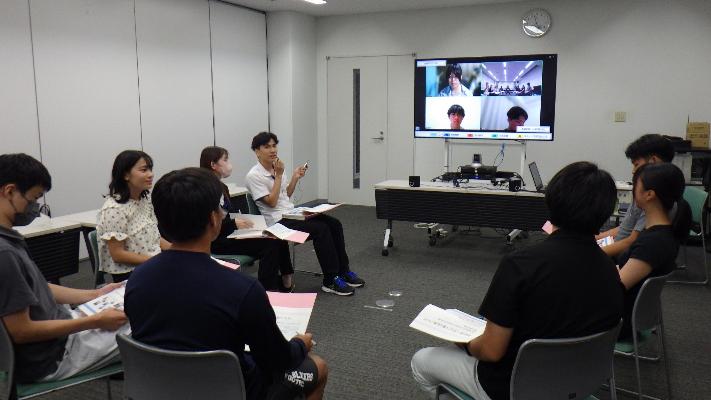 椅子に座り会議を行っている