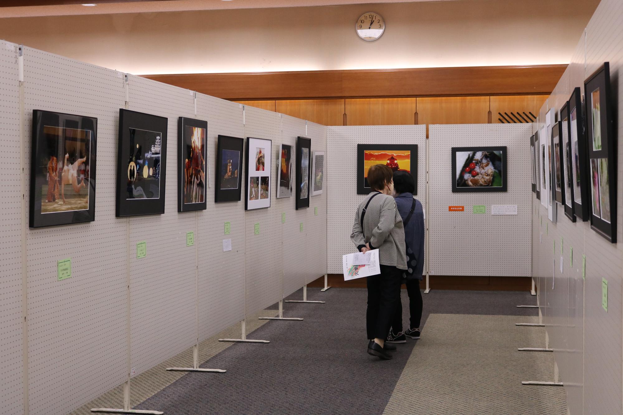 第21回宍粟市美術展でパネルに展示されている作品を来場者が観覧している写真