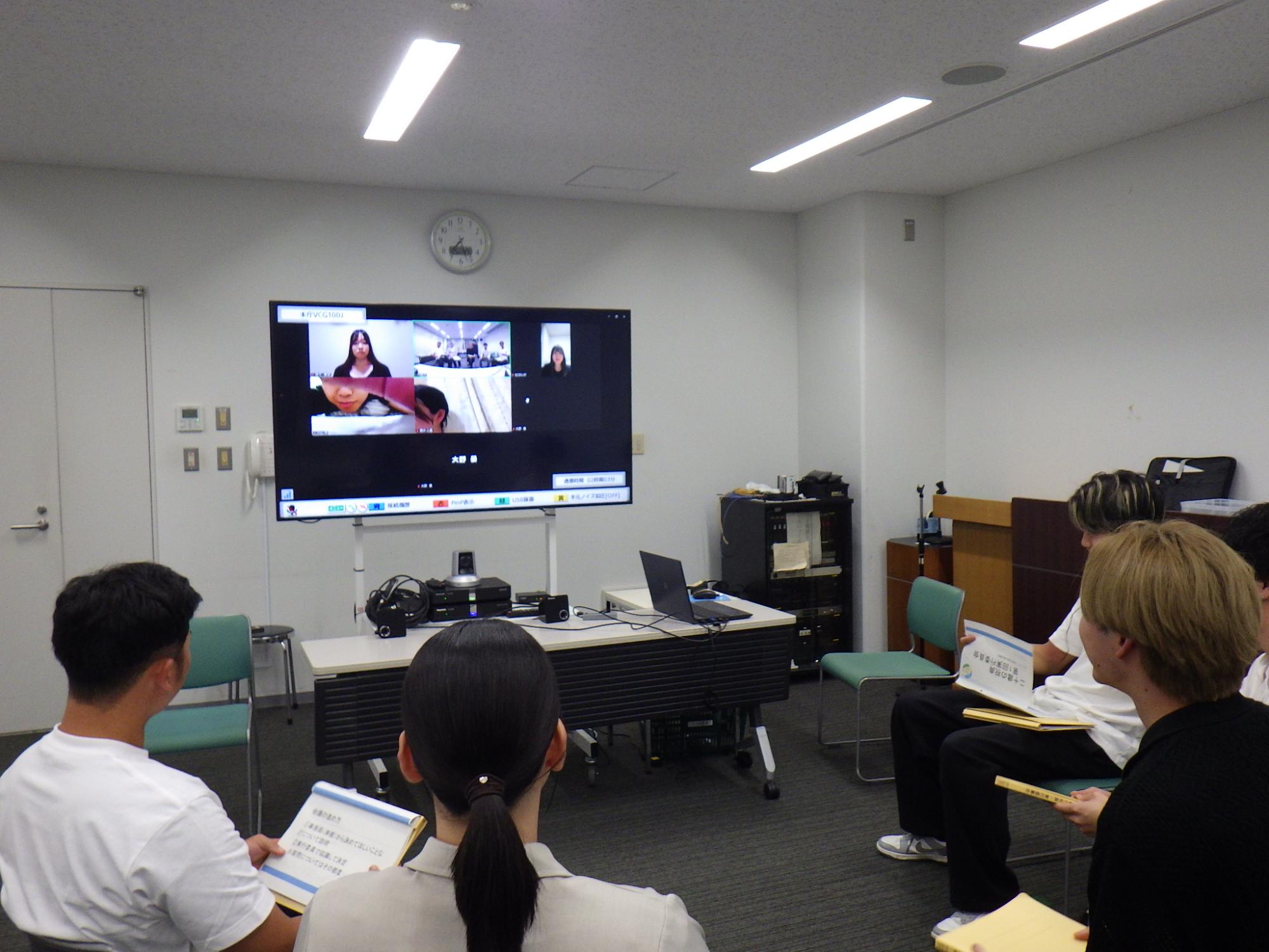 椅子に座り会議を行っている