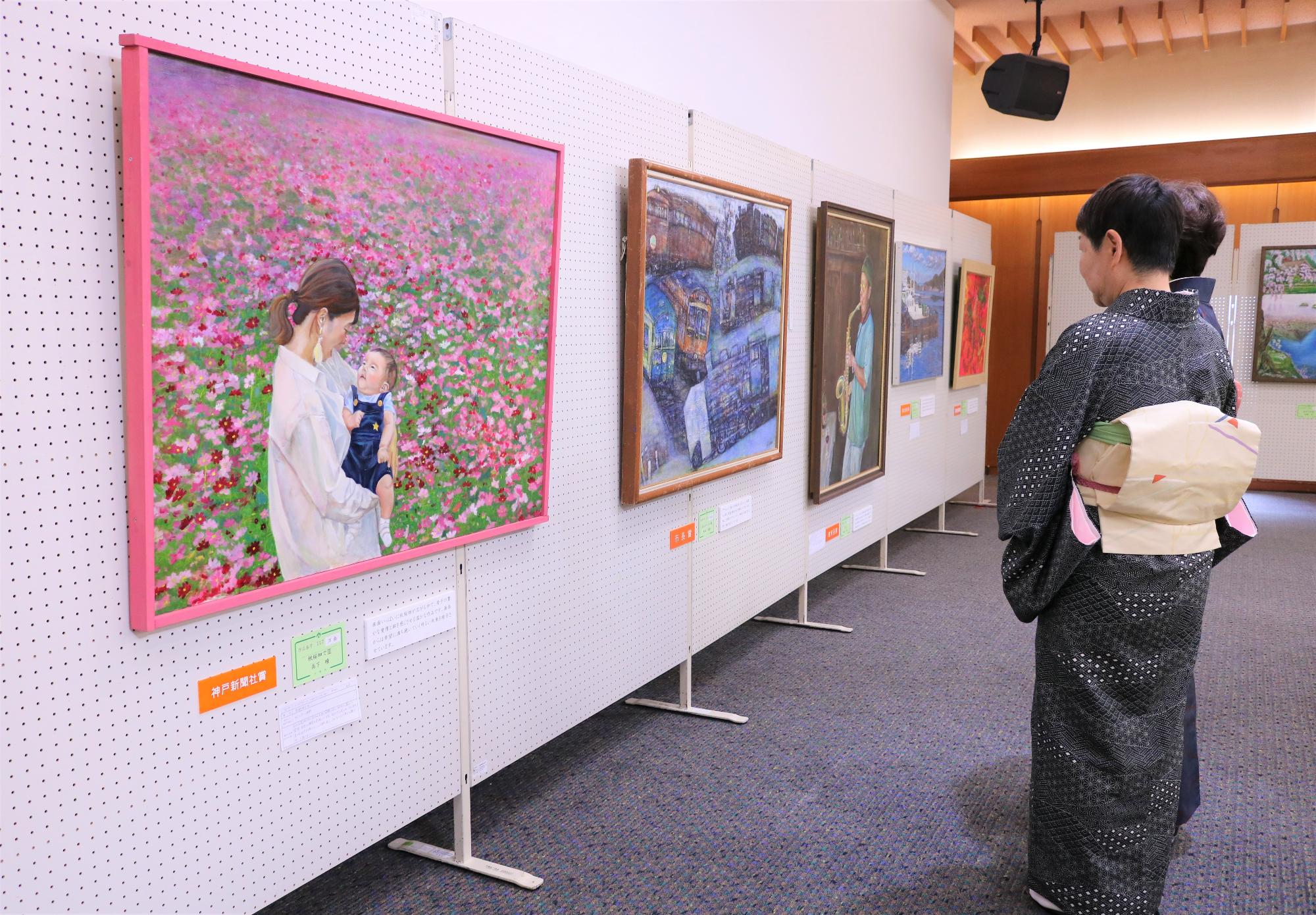第21回宍粟市美術展でパネルに展示されている作品を来場者が観覧している写真