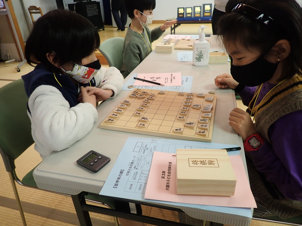 子どもたちが向かいあって将棋を指している写真