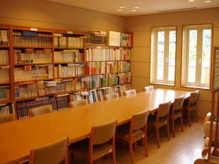 電球色の証明と木彫の家具が設置してある図書コーナーの写真