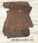発掘された焦茶色のひび割れた縄文土器の一部の写真