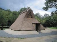 屋根が地面に置かれているような形の縄文時代の竪穴式住居の外観写真