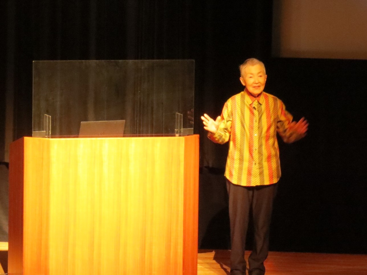 やまさき文化大学50周年記念講演のステージ上で講演する講師の若宮正子先生の写真