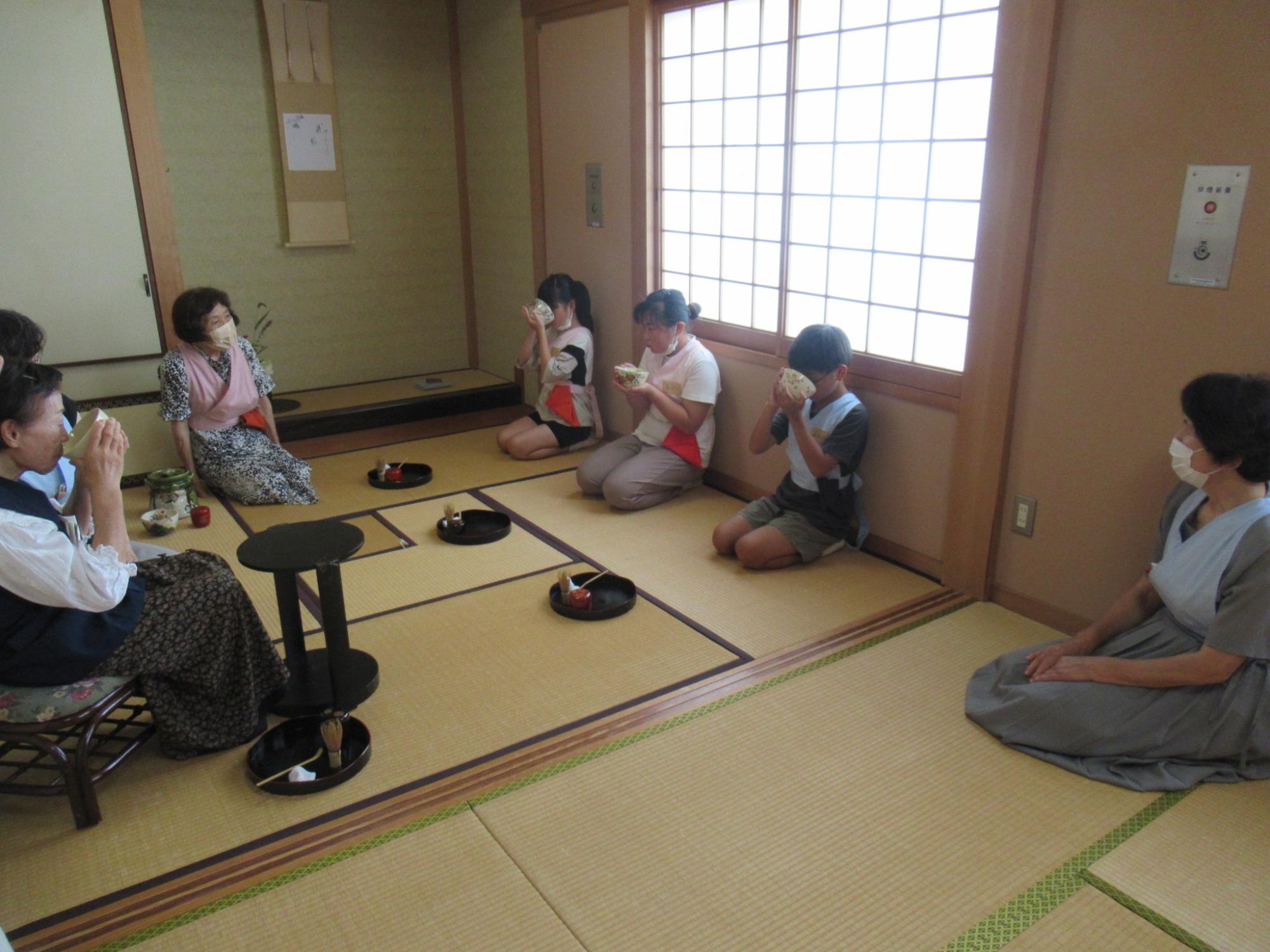 参加者が自身で点てたお茶を味わっている写真