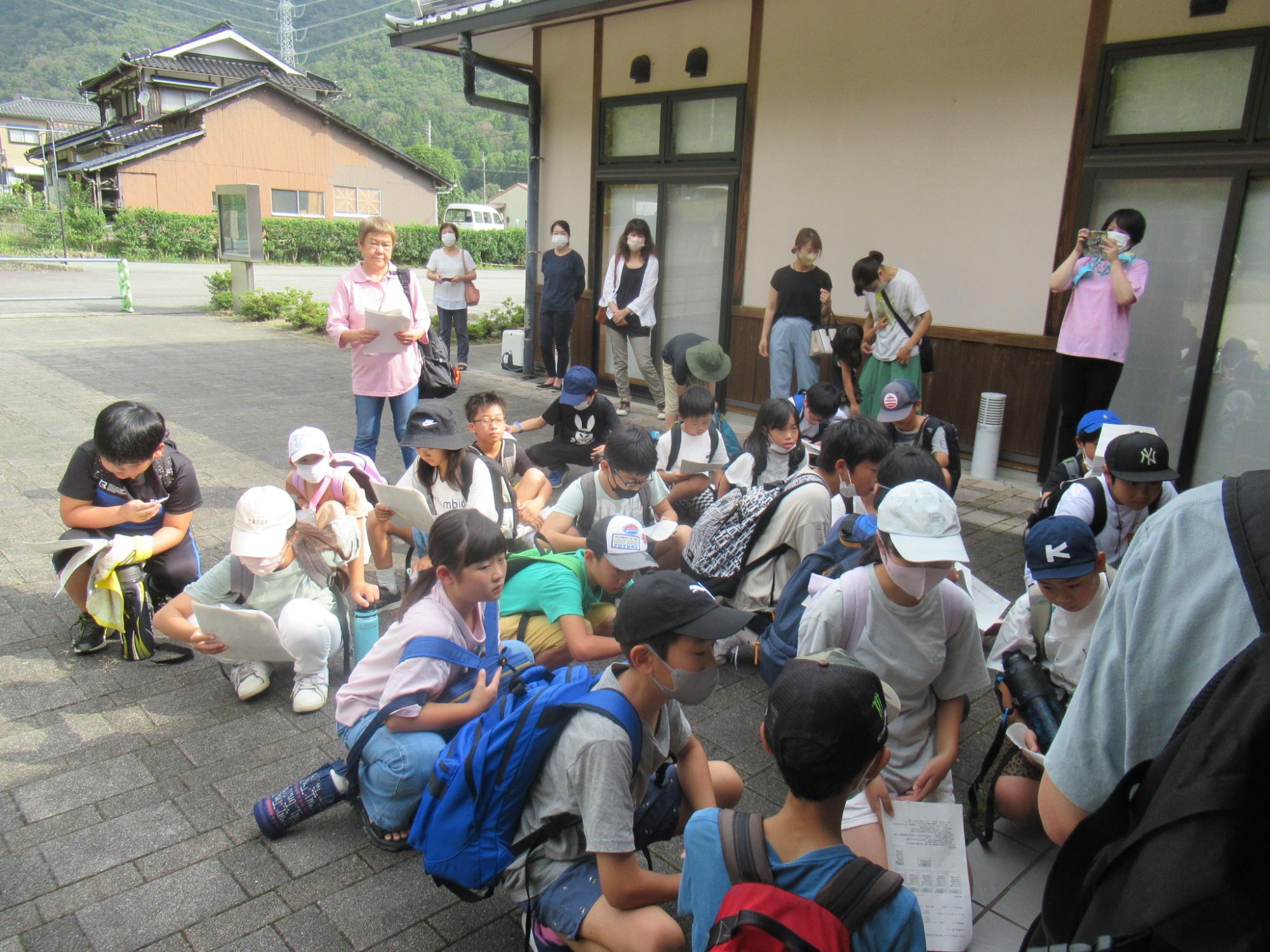 参加者が学遊館に集合し、研修のスケジュール説明を聞いている写真