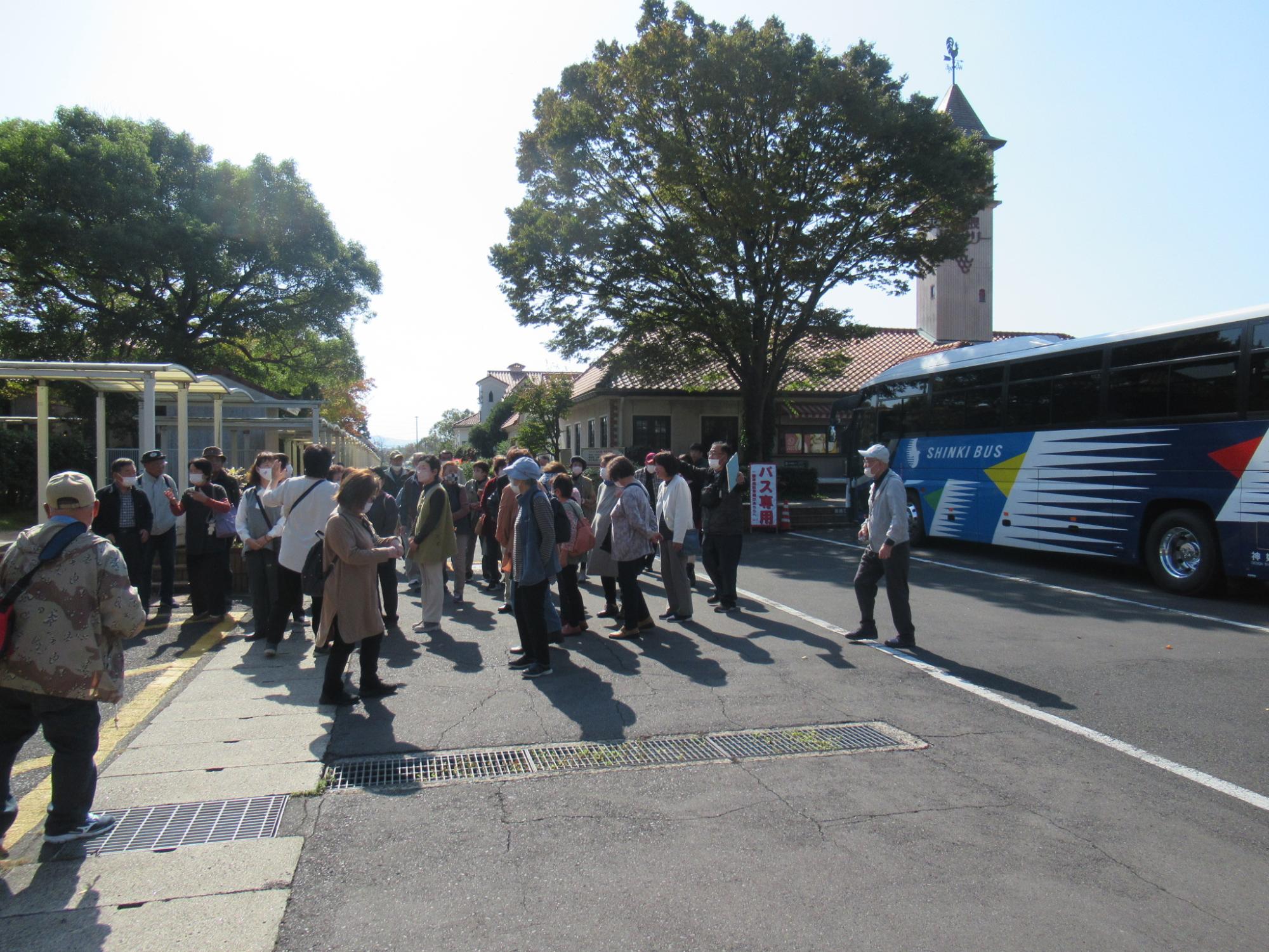 島根ワイナリーに到着したやまさき文化大学の受講者が移動に使っているバスから降車して集まっている写真