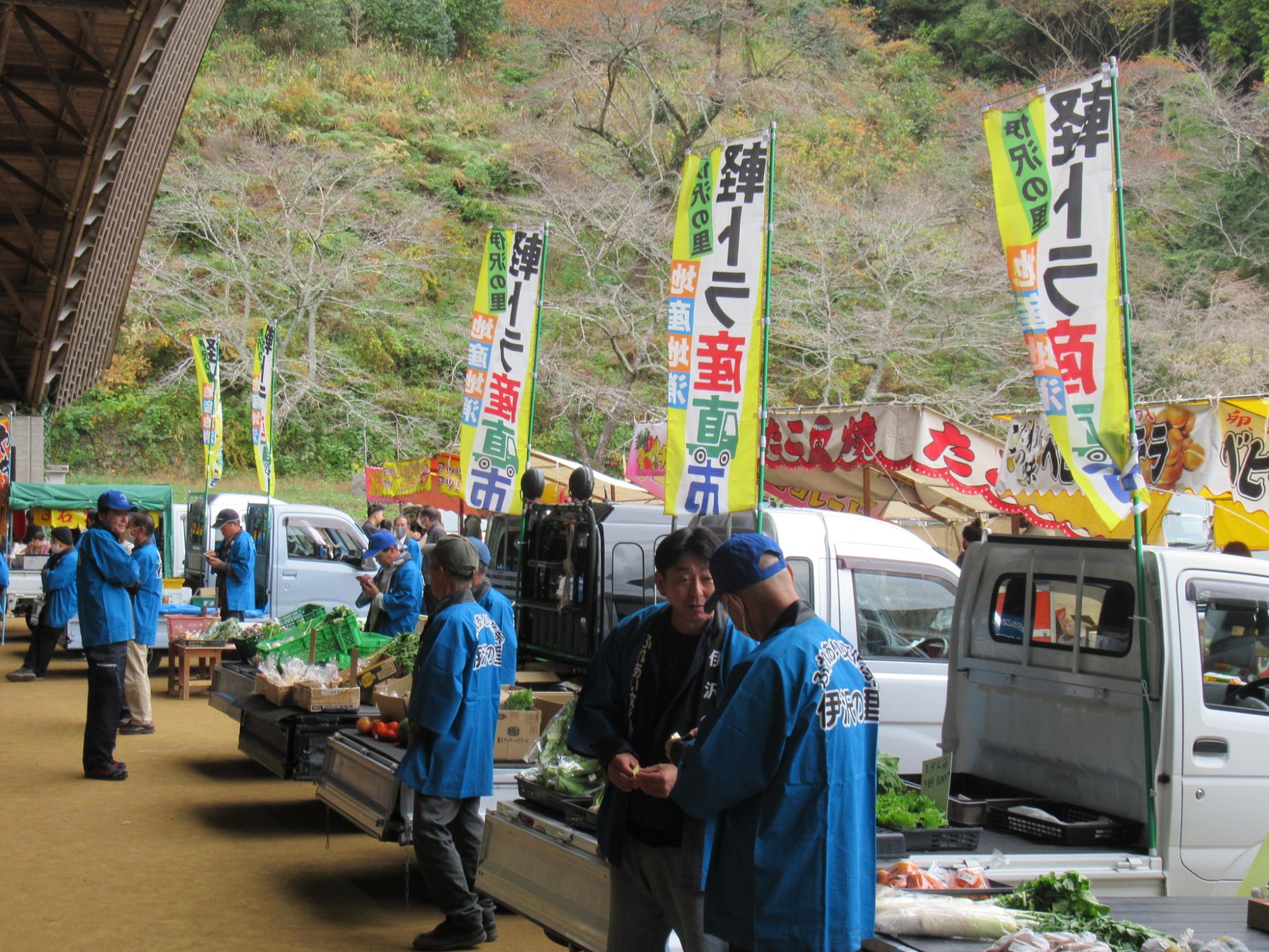 野菜や果物を販売する軽トラ市の参加者や車両が並んでいる写真