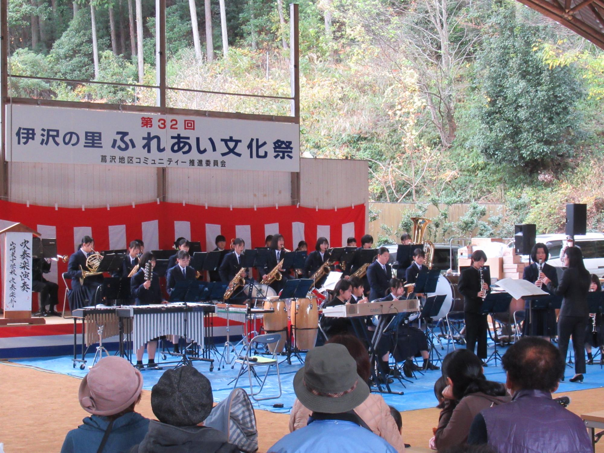 山崎東中学校吹奏楽部がステージで演奏している写真
