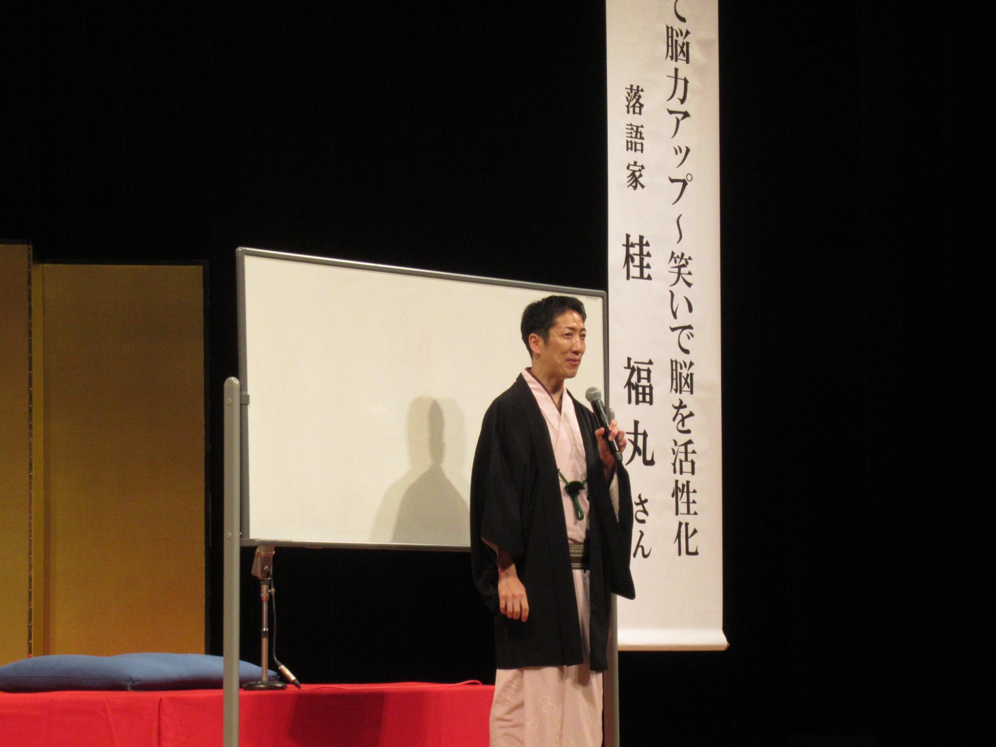 桂福丸さんが壇上で初めの挨拶をされている写真
