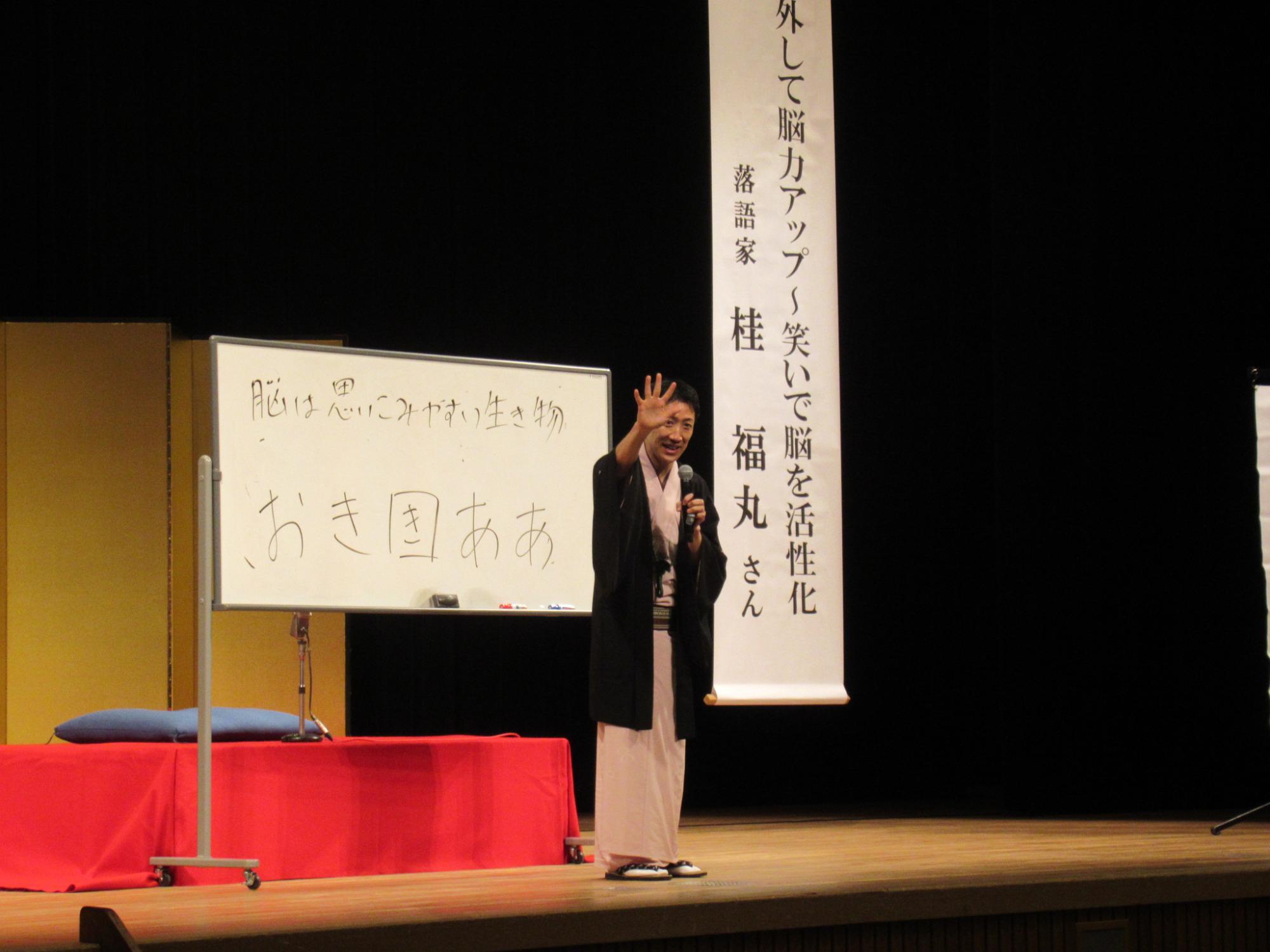ホワイトボードを使って桂福丸さんが講義をされている写真