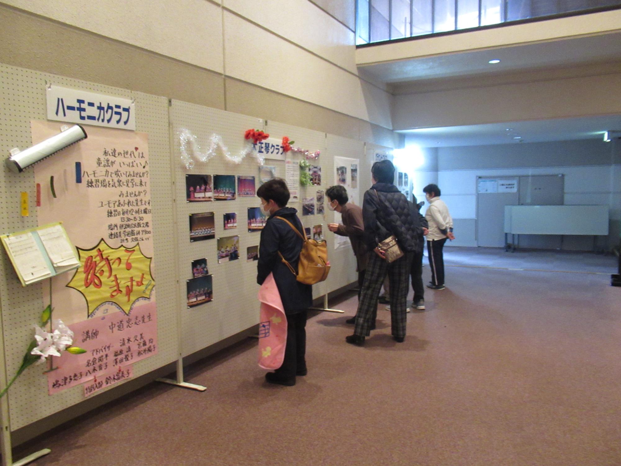 山崎文化大学の学生らの作品を鑑賞する来館者らの写真