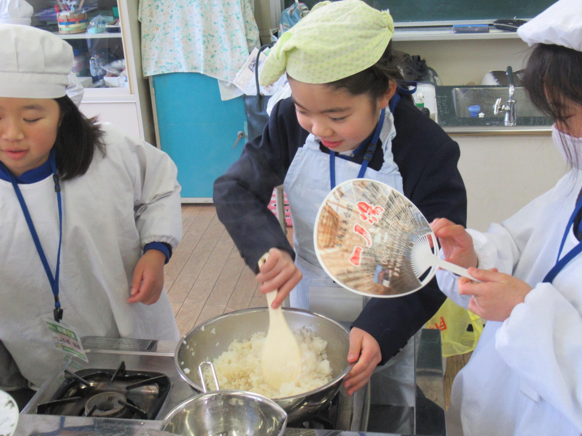 教室に参加している3人の子どもが作業を分担しながら酢飯を作っている写真